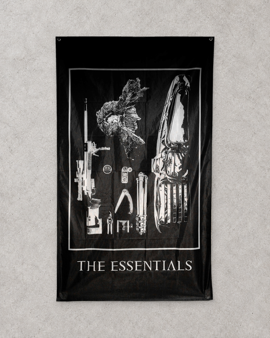 The Essentials flag hanging upright on a pale textured wall
