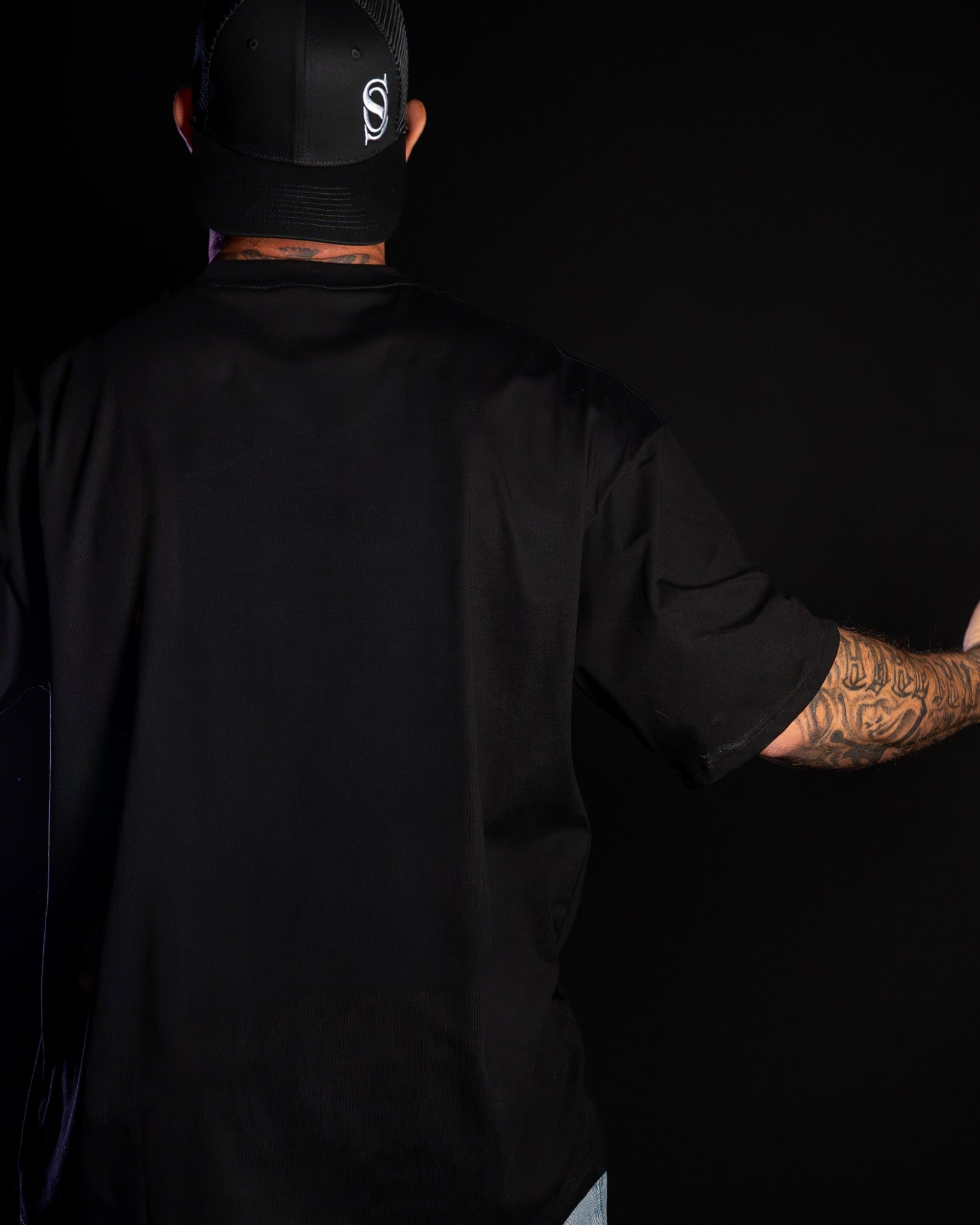 Original back photograph of Guy in an unprinted black drop-shoulder tee
